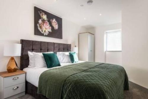 ハルにあるModern 2BR Haven in Hull City Centerのベッドルーム1室(緑と白の枕が備わる大型ベッド1台付)