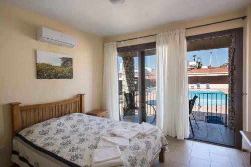 a bedroom with a bed and a balcony at Napiana Apartments in Ayia Napa
