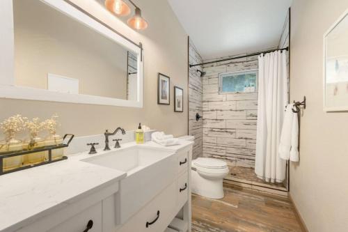 a white bathroom with a sink and a toilet at New The Pine Getaway Lots of Room Hot Tub Views in Conifer