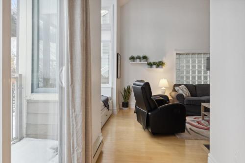 ein Wohnzimmer mit einem schwarzen Stuhl und einer Couch in der Unterkunft Slopeside Ski In Ski Out Second Floor Condo in Blue Mountains