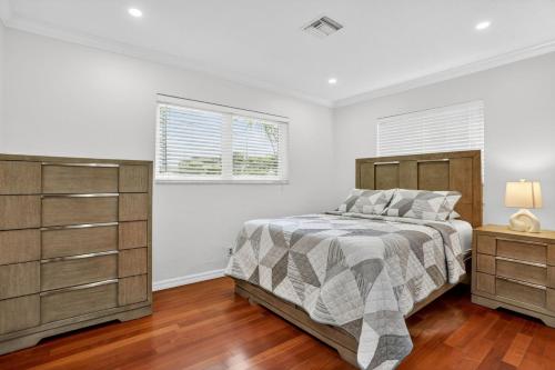 a bedroom with a bed and a dresser and two windows at Siena Villas in Pompano Beach