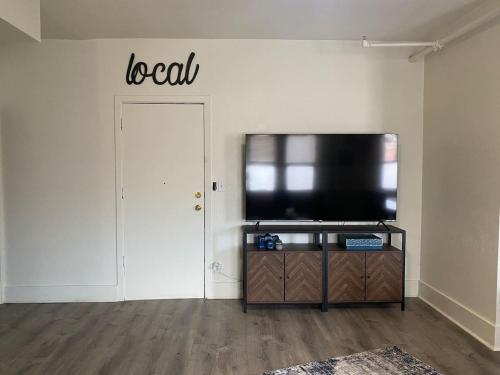 a living room with a flat screen tv and a door at 216 The Governors Suite at The George in Klamath Falls