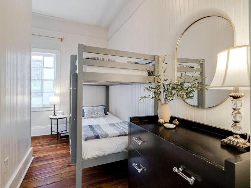 a bedroom with a bunk bed and a desk with a mirror at Waldburg Cottage in Savannah