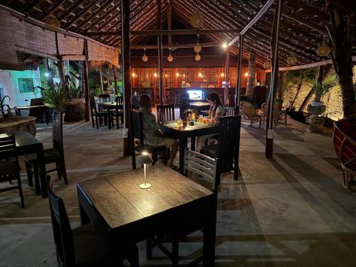 zwei Personen sitzen an einem Tisch in einem Restaurant in der Unterkunft IN Lanka Hotel and Restaurant in Tangalle