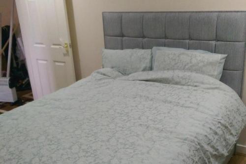 a bedroom with a bed with a gray headboard and pillows at House-Sleeps 5 person -Etihad Stadium 15 min drive in Ashton under Lyne