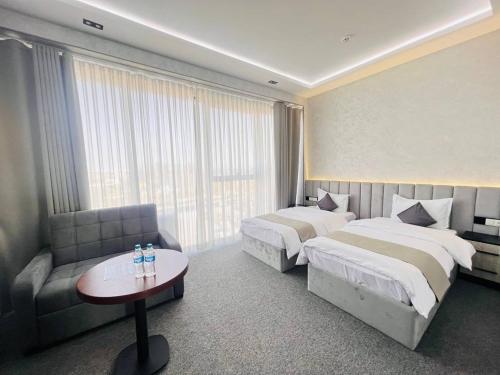 a hotel room with two beds and a couch at Loren Hotel in Tashkent