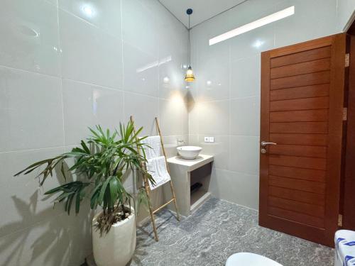 baño con lavabo, aseo y planta en Livana Villa 02, en Kerobokan