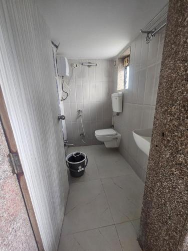 um banheiro com vaso sanitário, pia e banheira em The Agerra Beach Resort em Diveagar