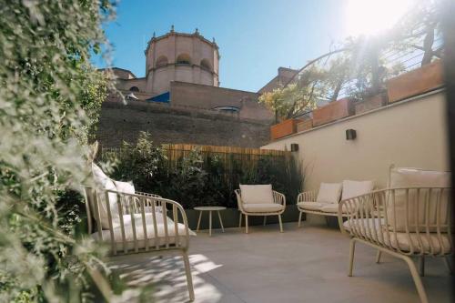 a patio with chairs and tables and a building at Atelier Inn Vaticano in Rome