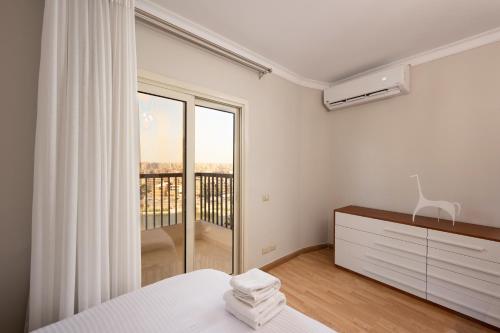 una camera da letto con un letto e una finestra con balcone di VESTA - Nile Zamalek Residence a Il Cairo