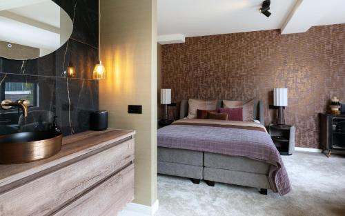 a bedroom with a bed and a bathroom with a sink at Myko Boutique BenB in Zwolle
