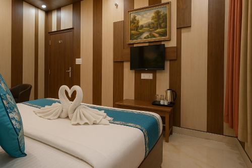 a hotel room with a bed with a towel on it at Ramayana Grand Hotel Ayodhya - Just Steps Away from Ram Mandir in Ayodhya