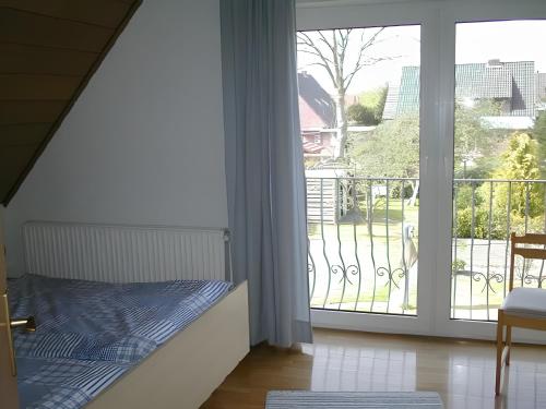 1 dormitorio con 1 cama junto a una puerta corredera de cristal en Ferienhaus Poth, en Bübbens