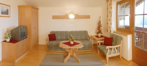 un salon avec un canapé et une télévision dans l'établissement Appartmenthaus Geroldhof, à Ramsau am Dachstein