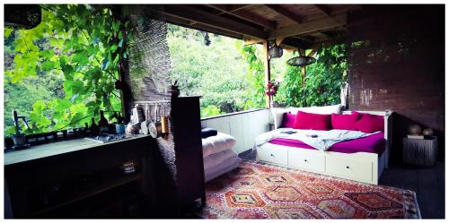 a room with a bed and a window with pink pillows at Sans Murs Dans la Nature in San-Martino-di-Lota