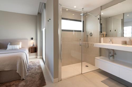 Un baño con ducha, cama y lavabo. en Mara's Apartments Higuerón West - Scandinavian Luxury - Seaviews & Natural Landscapes, en Fuengirola
