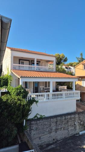 a large white house with a white fence at Apartmany Tisno Perica in Tisno