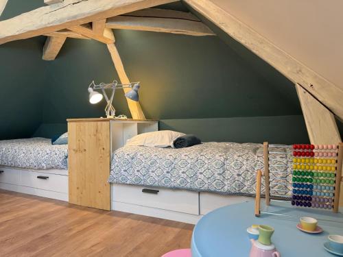 a bedroom with a bunk bed in a attic at l'Ancien Bistrot in Saint-Martin-de-Bréthencourt