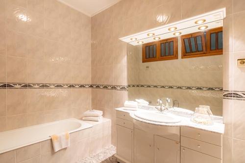 a bathroom with a tub and a sink and a bath tub at Quinta dos Arcos in Barcelos