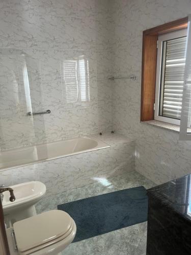 a bathroom with a toilet and a bath tub at Quinta dos Arcos in Barcelos