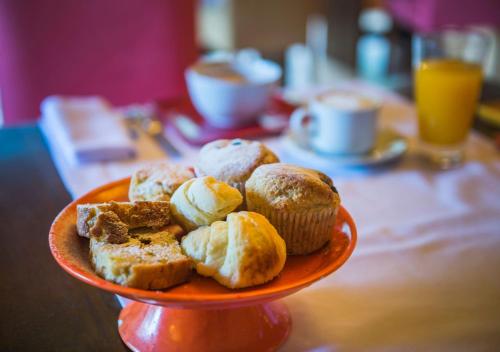 un plato de magdalenas y pan en una mesa en Rio Hermoso Hotel De Montaña, en San Martín de los Andes