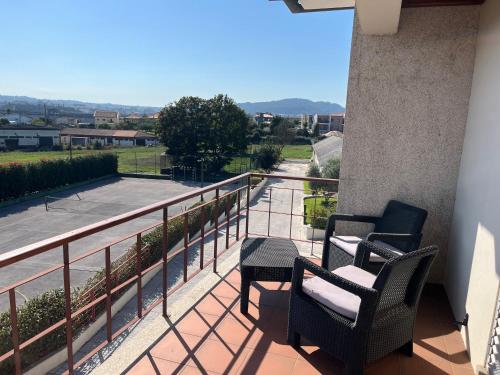 two chairs and a table on a balcony with a view at Quinta dos Arcos in Barcelos