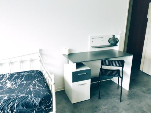 ein Schlafzimmer mit Schreibtisch, Bett und Stuhl in der Unterkunft P' TI ECRIN DE VERDURE in Illzach