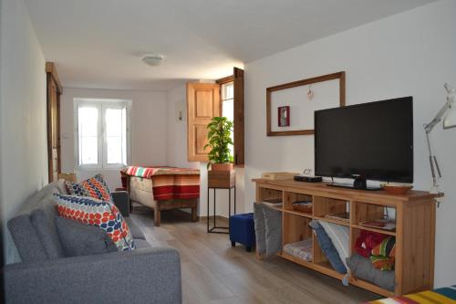 a living room with a flat screen tv on a table at Casa Aurora in Escusa