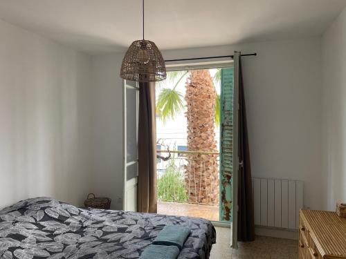 a bedroom with a bed and a large window at La villa au palmier - 10ch, 2sdb, toit terrasse in Perpignan
