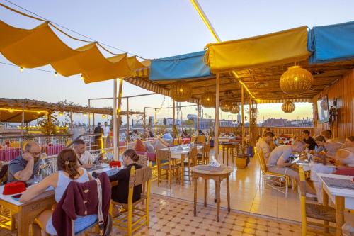 un grupo de personas sentadas en mesas en un restaurante en Riad El Kennaria, en Marrakech