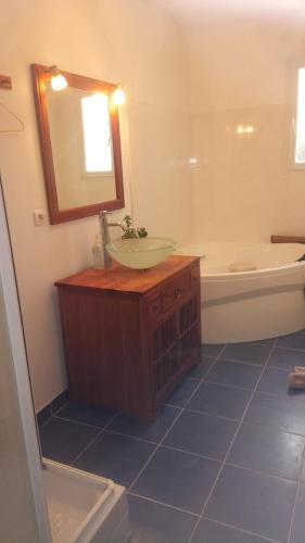 une salle de bains avec lavabo, miroir et baignoire dans l'établissement Maison familiale idéale pour vacances, à Saint-Georges-dʼOléron