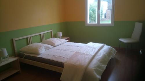 une chambre avec un lit avec des draps blancs et une fenêtre dans l'établissement Maison familiale idéale pour vacances, à Saint-Georges-dʼOléron