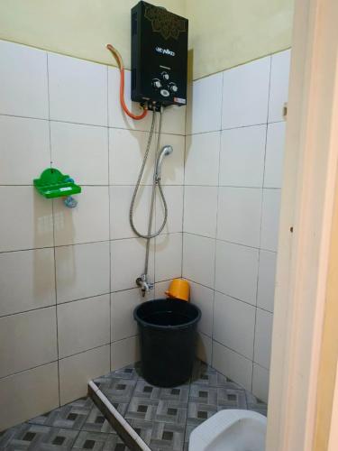a bathroom with a toilet and a bucket at Pondok Wisata Karapyak Jajapin in Nusa Were