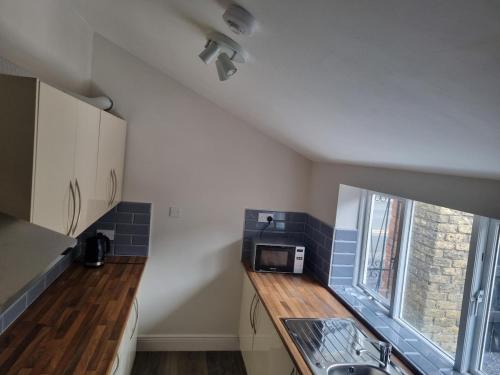 a small kitchen with a sink and a microwave at Adare House Newbridge in Newbridge