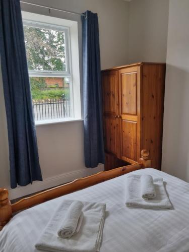 a bedroom with a bed with two towels on it at Adare House Newbridge in Newbridge