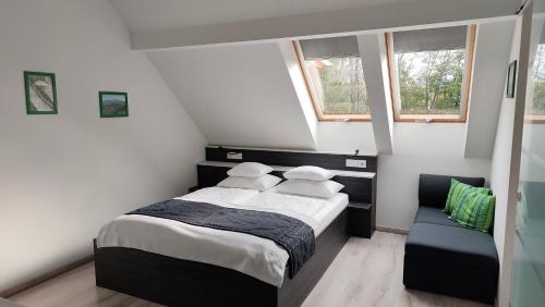 a small bedroom with a bed and a couch at Darázshegyi Panzió és Faházak - Panzió épület in Mátraszentimre