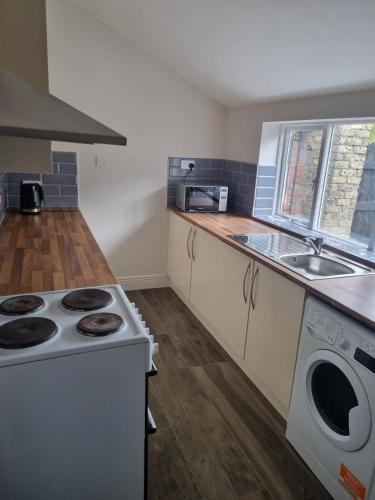 a kitchen with a stove top oven next to a sink at Adare House Newbridge in Newbridge
