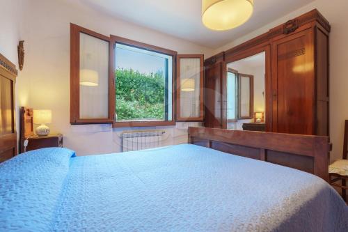 a bedroom with a blue bed and a window at La Casina a Schiopparello - Goelba in Portoferraio