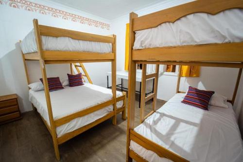 a room with two bunk beds and a desk at Casa Águila y Cóndor Miraflores in Lima