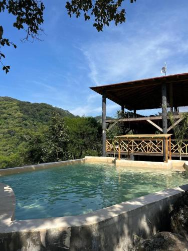 a swimming pool with a gazebo in the background at Oasis Hotel & Resort Mazamitla in Caliguana