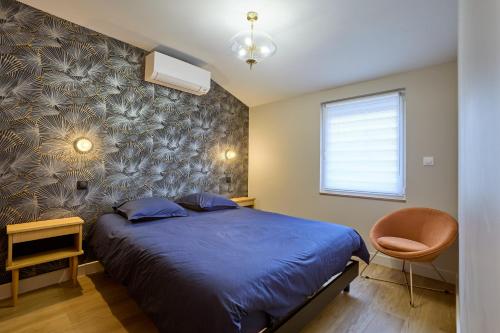 a bedroom with a blue bed and a chair at Pont de Peira - 2.5 km dAgen in Le Passage