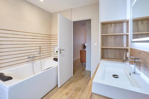 a bathroom with a tub and a sink at Pont de Peira - 2.5 km dAgen in Le Passage