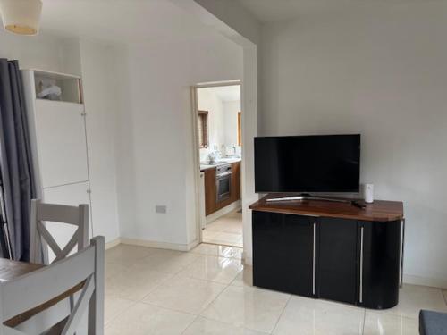a living room with a flat screen tv on a table at 2 Willow Cottage in Takeley