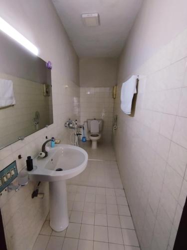 a bathroom with a sink and a toilet at HillTop Hotel in Karachi