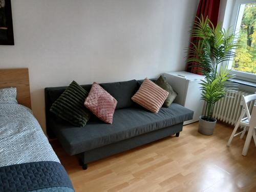 a living room with a blue couch with pillows at Nuri Studio in Augsburg
