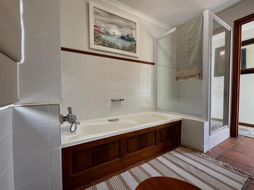 a bathroom with a bath tub and a sink at San Ma Lou in Paternoster