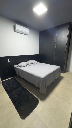 a bedroom with a bed with a black headboard at Rooftop Studio Premium in Bom Despacho