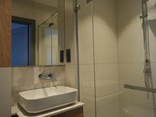 a white bathroom with a sink and a shower at Horizon in Władysławowo