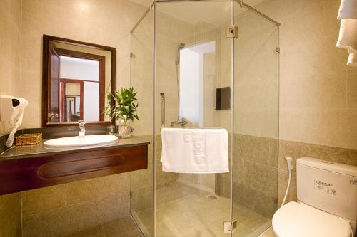 a bathroom with a shower and a sink and a toilet at Hoi An Green Apple Hotel in Hoi An
