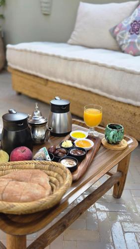 een salontafel met een dienblad met eten en sinaasappelsap bij Riad Laly Tourisme Eclairé Le bijou de la medina in Marrakesh